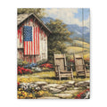 A vertical canvas wall art print depicting a rustic red barn with an American flag, two wooden chairs, and a scenic mountain valley in the background.